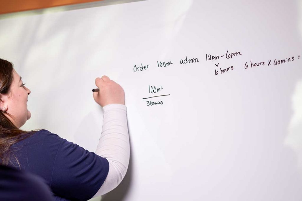 student writing on whiteboard