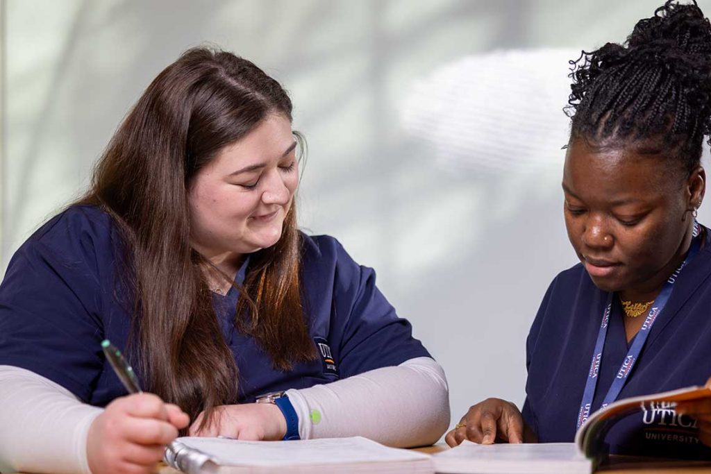 two nursing students studying at table