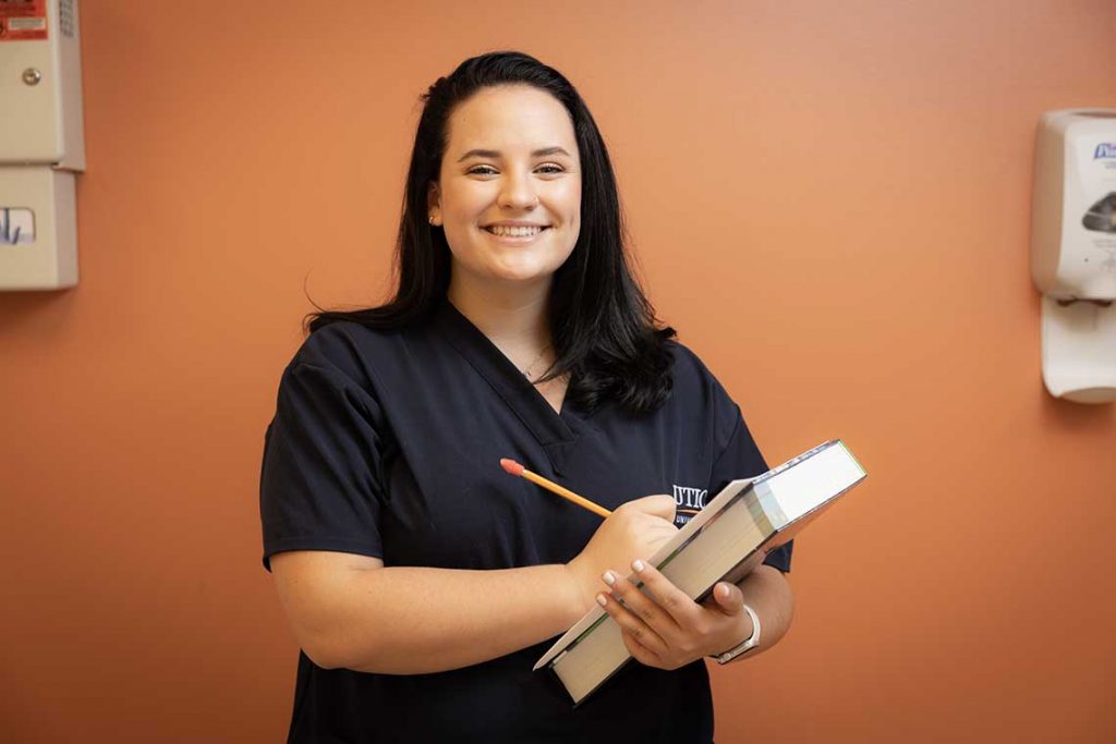 Utica ABSN student holding textbooks